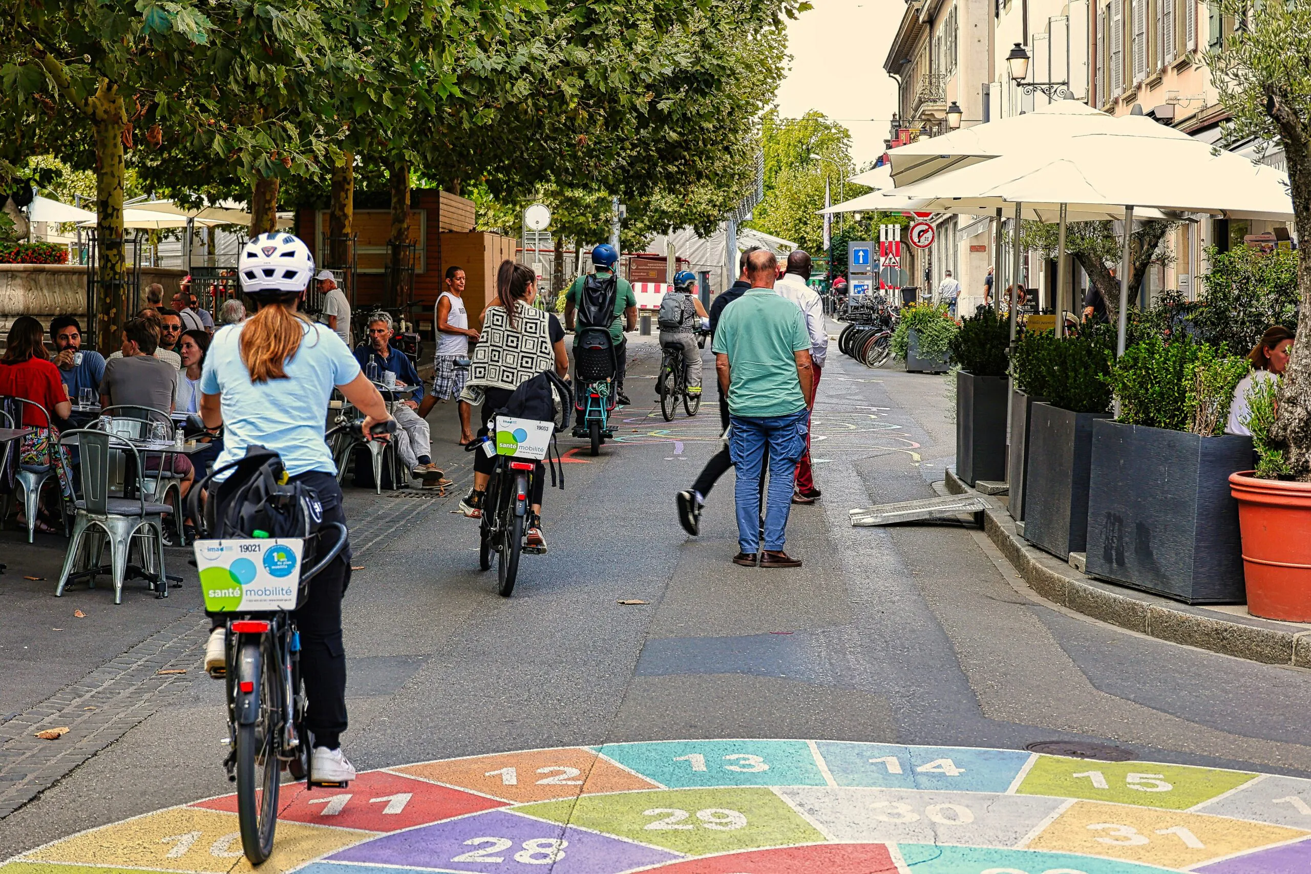 A group of people riding bikes down a street